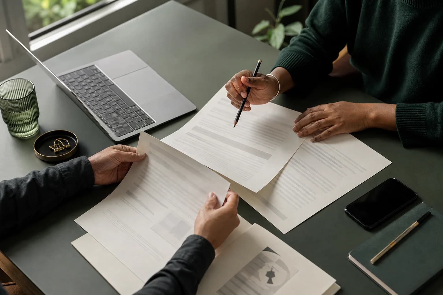 Deux personnes vérifient ensemble des documents sur une table de travail
